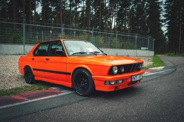 Riga, Letonya - Eylül 2018: Turuncu Bmw E28 araba yarış yolda kalıyor