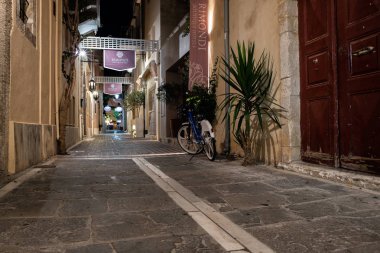 Rethymno, Yunanistan - Ağustos 2018: Naight dar sokakta park edilmiş motorlu scooter eski şehir merkezi ile