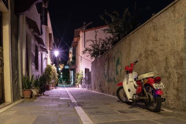 Rethymno, Yunanistan - Ağustos 2018: Naight dar sokakta park edilmiş motorlu scooter eski şehir merkezi ile