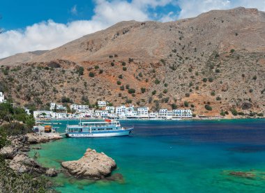 Girit, Yunanistan-Ağustos 2018: Girit adasının Güney kesiminde bulunan Loutro kasabasının yakınındaki şeffaf mavi lagün ve geleneksel Yunan evlerinde panoramik görünüm.