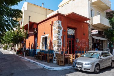 Girit, Yunanistan-Ağustos 2018: Palaiochora kasabasının merkezinde Park edilmiş araba ile geleneksel Yunan kafe dış.