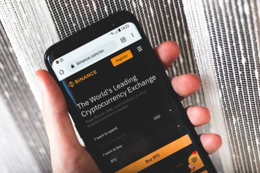 Binance şifreleme para değişimi web sitesi arayüzü elinde tutulan bir akıllı telefon üzerinde Kripto para birimi günü kapalı tutuluyor bir cep telefonu üzerinde web uygulaması hizmeti ana sayfası