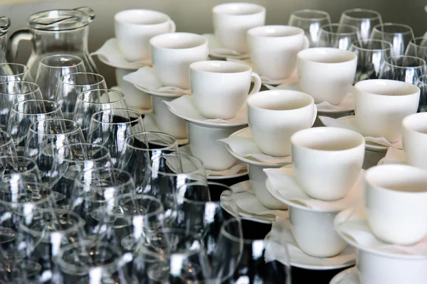 preparation for corporate party set of dishes cups and glasses