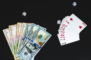 Yukarıdan görüntüleyin. Yukarıdan görüntüleyin. siyah bir arka plan üzerinde büyük notlar dolar ve Grivnası. Para, zarlar ve kartlar 