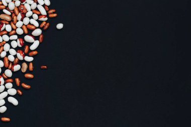 metin için alan ile arka plan. Yukarıdan görüntüleyin. siyah bir arka plan üzerinde dağınık çok renkli fasulye. kahverengi ve beyaz fasulye