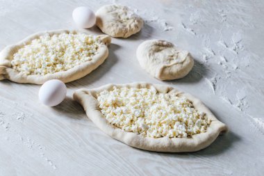 Suluguni Peynirli Ev Yapımı Ajarian Khachapuri. Çalışma aşaması. Pişirme için hazırlık. Pişirmeden önce Çiğ Suluguni