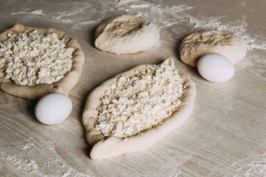 Suluguni Peynirli Ev Yapımı Ajarian Khachapuri. Çalışma aşaması. Pişirme için hazırlık. Pişirmeden önce Çiğ Suluguni