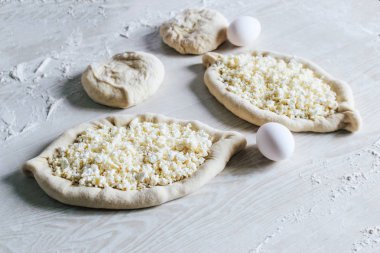 Suluguni Peynirli Ev Yapımı Ajarian Khachapuri. Çalışma aşaması. Pişirme için hazırlık. Pişirmeden önce Çiğ Suluguni