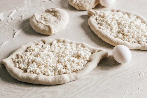 Suluguni Peynirli Ev Yapımı Ajarian Khachapuri. Çalışma aşaması. Pişirme için hazırlık. Pişirmeden önce Çiğ Suluguni