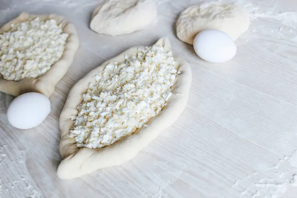 Suluguni Peynirli Ev Yapımı Ajarian Khachapuri. Çalışma aşaması. Pişirme için hazırlık. Pişirmeden önce Çiğ Suluguni