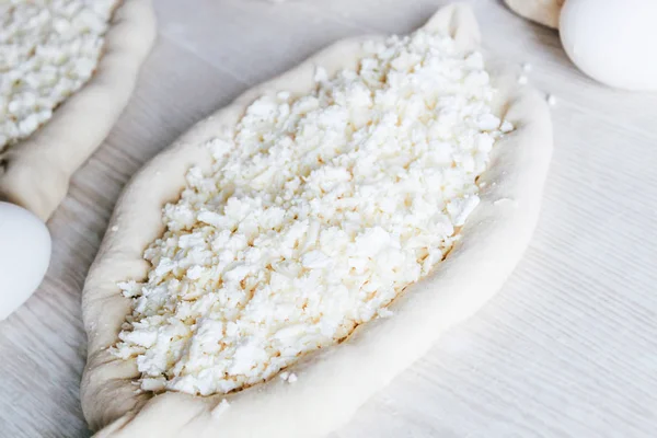 Suluguni Peynirli Ev Yapımı Ajarian Khachapuri. Çalışma aşaması. Pişirme için hazırlık. Pişirmeden önce Çiğ Suluguni