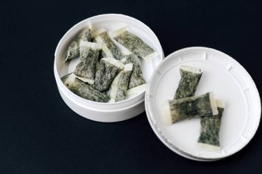 Yuvarlak kutu ve snus. Sigara yerine, nikotin torbaları..