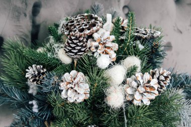 Kurumuş nilüfer çiçekleri, koniler ve ladin dallarından oluşan yeni yıl kompozisyonu. Noel için DIY buketi