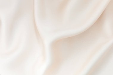Krem kumaş zarif bir şekilde örtülmüş pürüzsüz dokusu ve nazik kıvrımları sergileniyor. Doğal ışık ince parıltıyı güçlendirir. Sakinleştirici ve dingin bir atmosfer yaratır. Çeşitli kullanımlar için yardımcı olur..