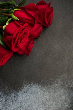 Dekoratif bir tabakta yüzük zinciri ve küpeler de dahil olmak üzere bir dizi altın mücevher bulunur. Tabak, dokulu gri bir yüzey üzerinde duran eşsiz bir tasarım içeriyor. 