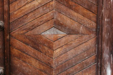 Karmaşık ahşap kapı zengin kahverengi kerestelerden yapılmış bir sembol deseni içeriyor. Eşsiz tasarım, farklı ahşap tonlarıyla işçiliği ön plana çıkarıyor. Bu kapı çevresinin kırsal çekiciliğini arttırır..