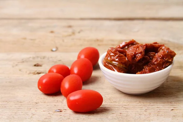 Sun dried tomatoes on wooden background table top view. — Stock Photo, Image
