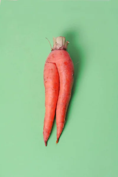 Trendy Ugly Vegetable Carrot Isolated On Green Background.