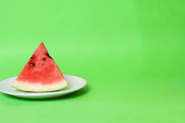 Beyaz Tabak ta Karpuz Dilimlenmiş Fotokopi Alanı ile Yeşil Backrground İzole.