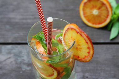 Kırmızı portakal ve cam nane ile soğuk içecekler kokteyl. Ahşap masada tazeleme limonata, açık. Yakın çekim, düz yatıyordu