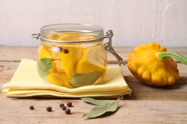 Trendy Fermente sebze buch kabak (patisson) ahşap masa üzerinde sarı peçete üzerinde cam kavanozda.