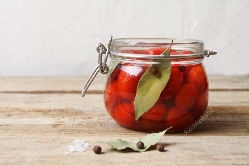 Trendy Fermented vegetables. Red Ripe Cherry Tomatoes in glass jar, selective focus.