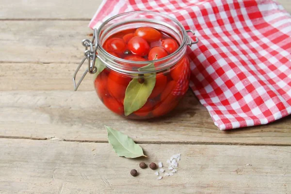 Trendi erjesztett zöldségek. Red RIPE Cherry paradicsom üvegedénybe, piros szalvéta a fából készült asztal, szelektív fókusz. — Stock Fotó