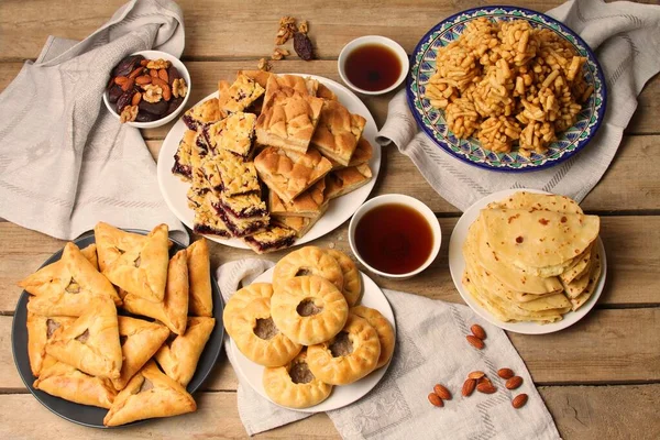 Geleneksel Tatar mutfağı. Chak chak, Kystybyi, Peremech, Echpochmak, Orijinal Kupa Piala 'da Peçeteli Tahta Masa Üzerinde Çay İçen Tatlı Belesh. Düz Yat, Üst Görünüm.