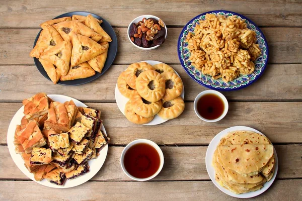 Geleneksel Tatar mutfağı. Echpochmak, Peremech, Kystybyi, Chak Chak, Sweet Belesh, Kurumuş Meyveler, Tahta Arkaplanda Tatar Çayı. Düz yatış, Üst Görünüm.