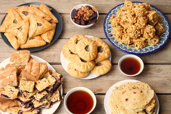 Geleneksel Tatar Yemekleri. Merkezin ortasında Peremech ve Echpochpak, Belesh, Çayla Chak Chak ve ahşap masa üzerinde kurutulmuş meyve ve fındık. Üst Görünüm, Düz Yat.