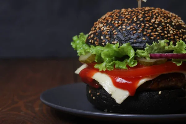 Schwarzer Burger Auf Teller Schwarzer Hintergrund Nahaufnahme Mit Kopierraum Seitenansicht — Stockfoto