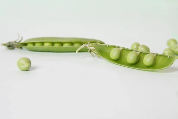 Taze yeşil bezelye kabuğu beyaz arkaplanda izole edildi.