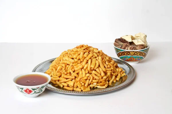 Geleneksel tatar tatlıları Chak chak, halva, çay fincanda piala, beyaz üzerine izole edilmiş.