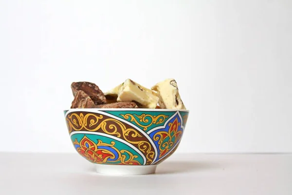 Beyaz arka planda izole edilmiş geleneksel tatar kâsesinde tatlı helva parçaları. Yan Görünüm.