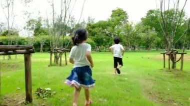 Bir erkek ve bir kız oynuyor parkta, parkın içinden mutluluk ile öğleden sonra ve neşeli faaliyetlerini gidiyor.