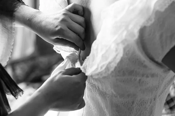 mom zips the bride\'s wedding dress
