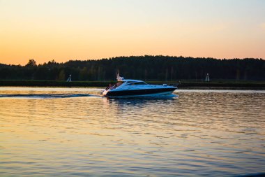 tekne gün batımında geniş bir nehir üzerinde yüzer