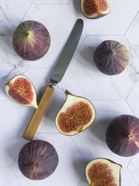 mermer bir masa üzerinde olgun incir. yarım meyve ve bıçak