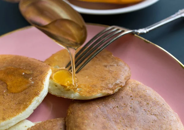 Madu Menuangkan Dari Sendok Pancake Piring Merah Muda — Stok Foto