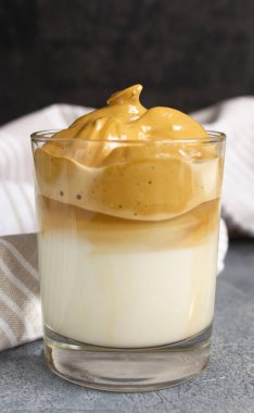 Beton bir masada beyaz keten havluyla çırpılmış kahve bardağı.