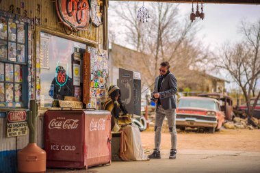 Genç adam bir vintage telefon retro bir benzin istasyonunda kullanır.