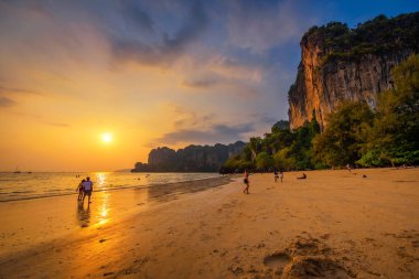 Turistler Railay Beach adlı gün batımından önce dinlenmek.