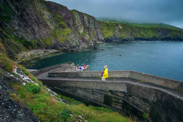 人がアイルランドで Dunquin の桟橋まで歩いて — ストック写真