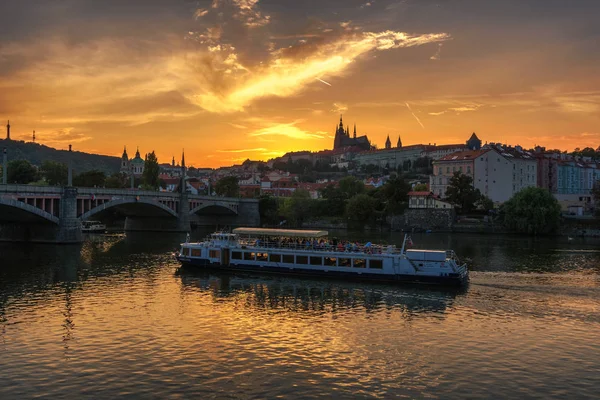 Risteilyvene näköalalla Prahan linnaan auringonlaskun aikaan — kuvapankkivalokuva