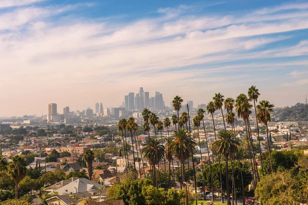 Los angeles Skyline bei Sonnenuntergang mit Palmen im Vordergrund — Stockfoto