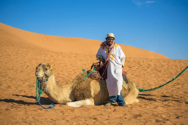 Berber człowieka z jego wielbłąd czeka na turystów w pustyni Sahara — Zdjęcie stockowe