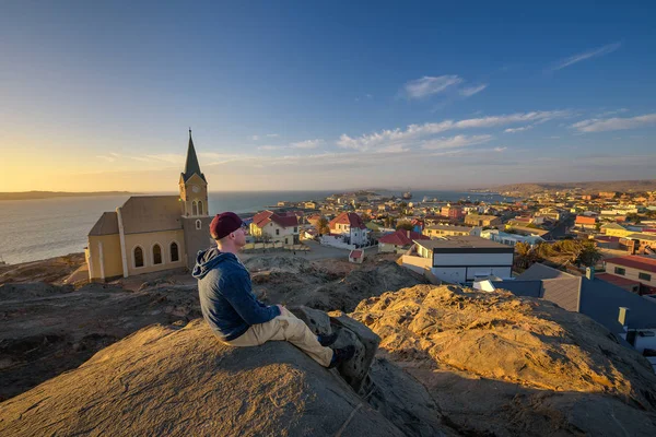 Turista in cima a una collina gode della vista di Luderitz in Namibia al tramonto — Foto Stock