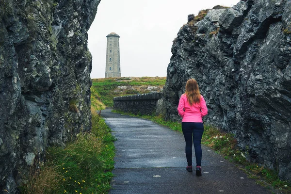 アイルランドのウィックローヘッド灯台に向かって歩く若い女性 — ストック写真