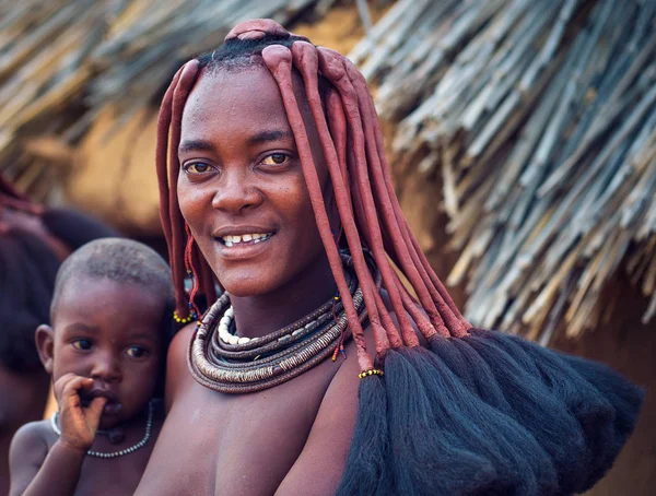 Portret van een jonge Himba vrouw met haar kind het dragen van traditionele kapsel — Stockfoto