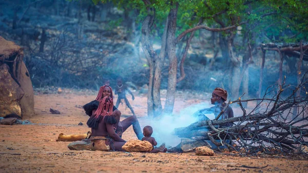 Mensen van de Himba stam zitten rond vuur in hun dorp — Stockfoto